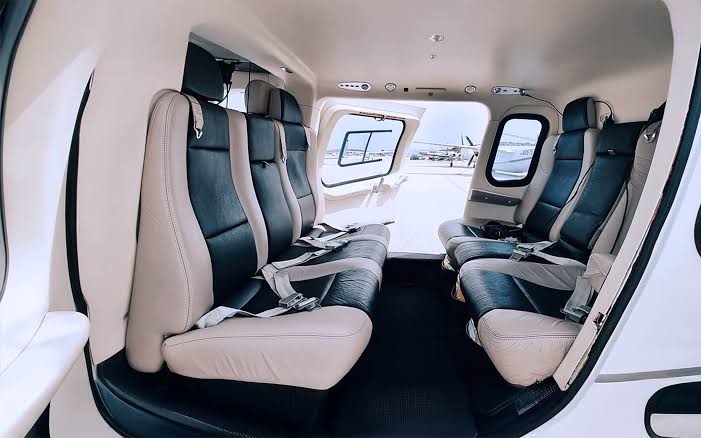 Luxurious leather seating and high-end aviation headsets inside the climate-controlled cabin of a VIP private charter helicopter