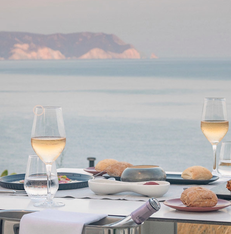 White wine glasses and gourmet appetizers at an open-air luxury restaurant