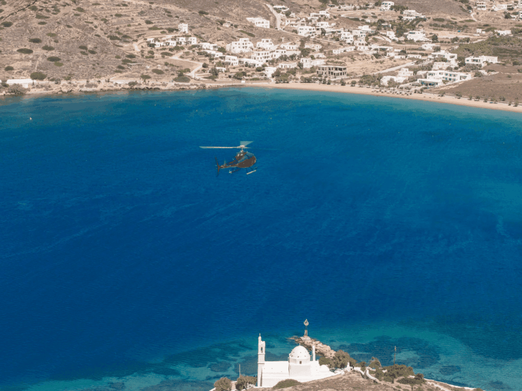 Private helicopter flying over Paros and the Aegean Sea