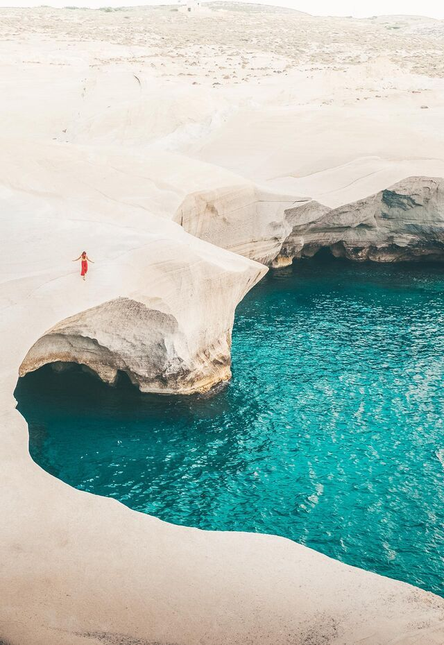 White lunar volcanic cliffs and turquoise waters at Sarakiniko Beach Milos
