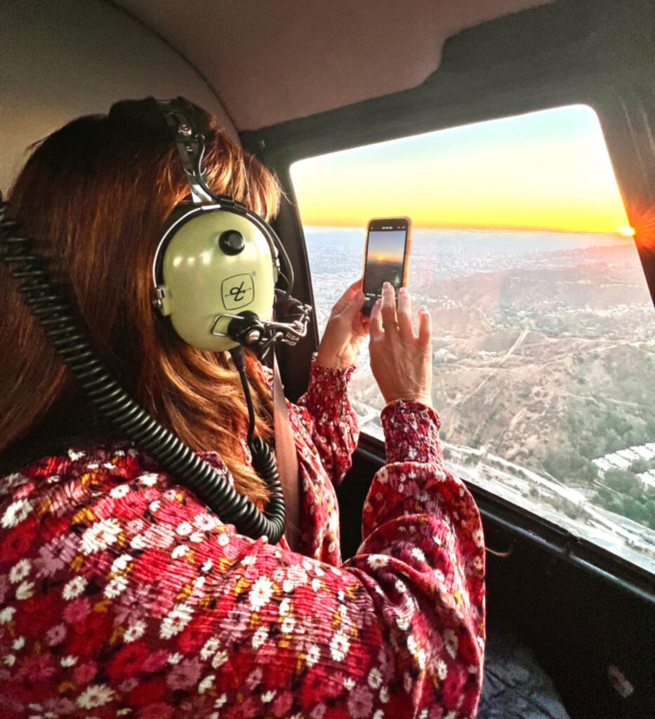 Passenger photographing sunset from a private helicopter flight from Athens to Santorini